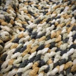 The stitches of a chunky knit blanket, up close